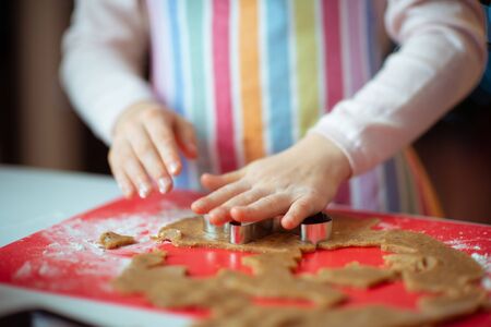 Closeup photo of children's hands making ginger cookies for Christmas eveの写真素材