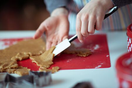 Closeup photo of children's hands making ginger cookies for Christmas eveの写真素材