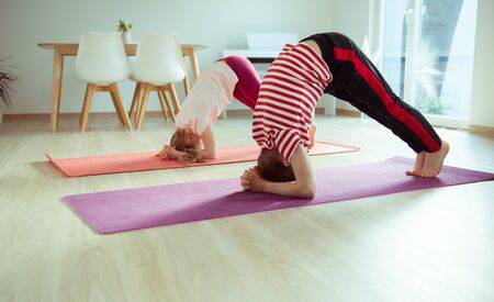 Happy siblings children making yoga at home dueing coronavirus quarantineの写真素材
