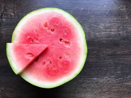 Juicy fresh watermelon slice on wooden backgroundの写真素材