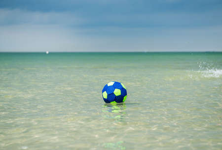 Colorful ball swimming in clear transparent turquoise water of Baltic sea