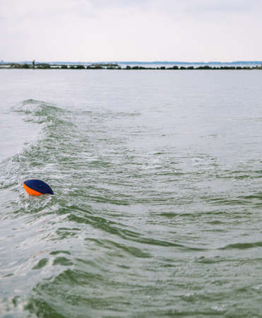Colorful ball swimming in clear transparent turquoise water of Baltic seaの写真素材