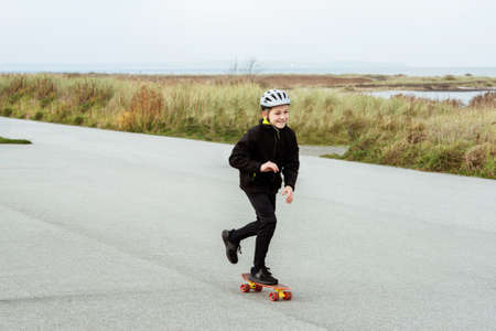 Happy teenager boy practice skateboarding on smooth asphaltの写真素材