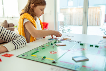 KIEL, GERMANY - February 14, 2021: Happy children having fun playing board game in cozy family time evening together with their parentsのeditorial素材