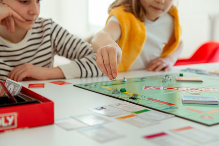 KIEL, GERMANY - February 14, 2021: Happy children having fun playing board game in cozy family time evening together with their parentsのeditorial素材