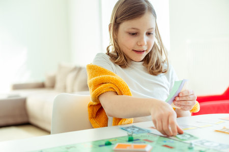 KIEL, GERMANY - February 14, 2021: Happy children having fun playing board game in cozy family time evening together with their parentsのeditorial素材