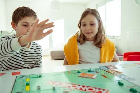 KIEL, GERMANY - February 14, 2021: Happy children having fun playing board game in cozy family time evening together with their parentsのeditorial素材