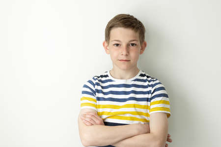 Portrait of handsome teen boy posing on white wall backgroundの写真素材