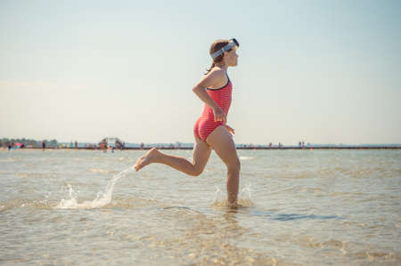 Happy little child girl running and having fun on the beach of Baltic sea at sunny summer dayの写真素材