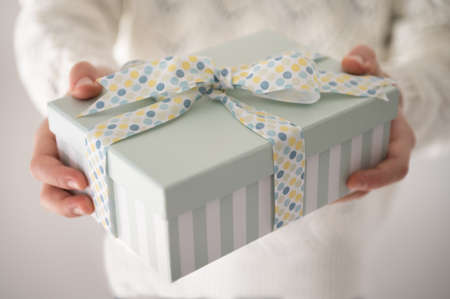 Close up photo of beautiful gift box in boy's hands at new year holidays or birthday celebrationの写真素材