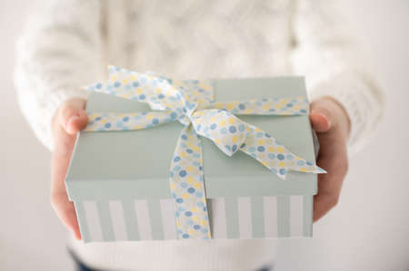 Close up photo of beautiful gift box in boy's hands at new year holidays or birthday celebrationの写真素材