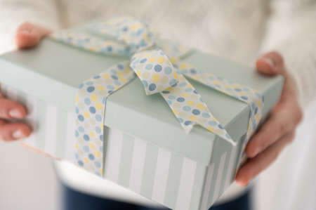 Close up photo of beautiful gift box in boy's hands at new year holidays or birthday celebrationの写真素材