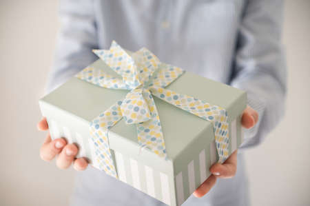 Close up photo of beautiful gift box in boy's hands at new year holidays or birthday celebrationの写真素材