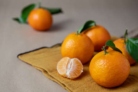 Closeup photo of fresh juicy clementine mandarins on orange napkin at winter timeの写真素材