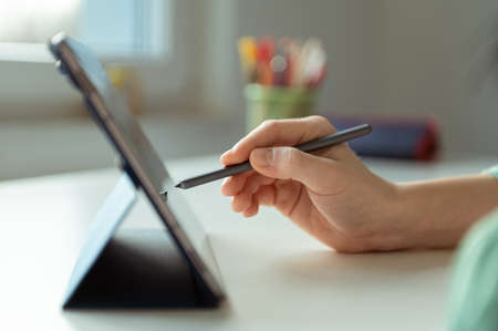 Close up photo of teens hand tapping with pen on tabletの写真素材