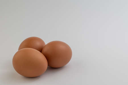 Closeup of several fresh brown eggs over white backgroundの写真素材