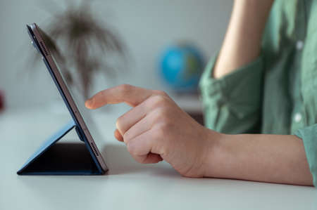 Child tapping tablet touchscreen with a finger closeup compositionの写真素材