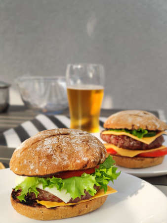 Close up photo of big tasty burger with green salad and fluffy bunの写真素材