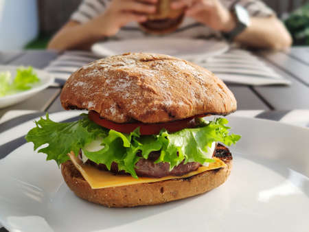 Close up photo of big tasty burger with green salad and fluffy bunの写真素材