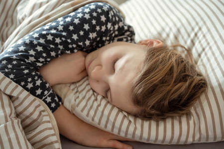 Close up portrait of pretty teen girl sleeping sweet in bedの写真素材