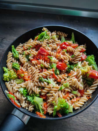 Tasty traditional italian pasta with colorful vegetables in skilletの写真素材