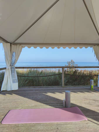 Photo of yoga mat and foam roller on wooden terrace outdoor with sea view in summerの写真素材