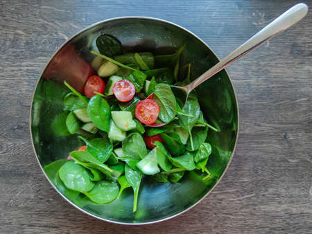 Top view photo of green healthy salad with other colorful vegetables such as cherry tomato and cucumberの写真素材