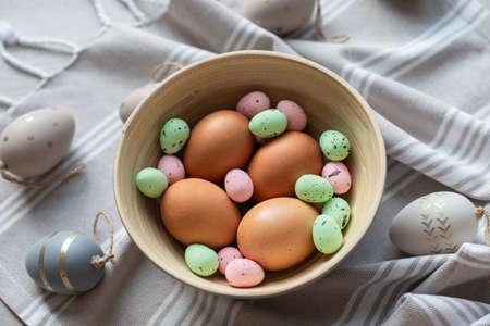 Flat lay photo of beautiful easter eggs in wooden basketの写真素材