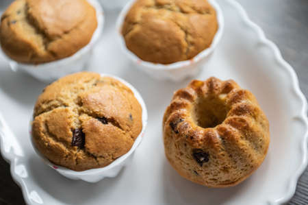 Yummy baked muffins with chocolate pieces on white plateの写真素材