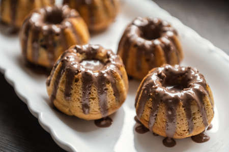 Coating with chocolate glaze tasty muffins at birthday partyの写真素材