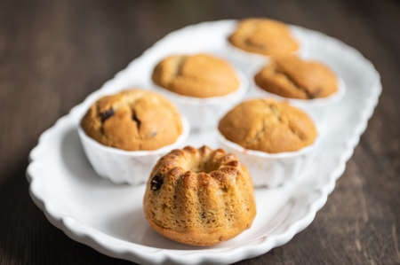 Yummy baked muffins with chocolate pieces on white plateの写真素材