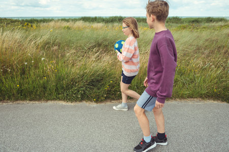 Happy teenage siblings or friends joyful walking at summer holidaysの写真素材