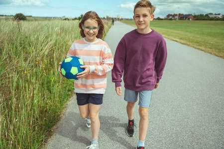 Happy teenage siblings or friends joyful walking at summer holidaysの写真素材