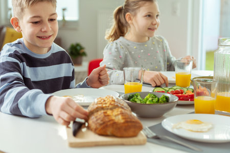 Teen children having healthy breakfast at home in the morning before schoolの写真素材