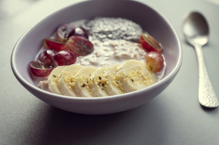 Healthy breakfast: cereal, grapes, banana, and chia with nuts dropsの写真素材