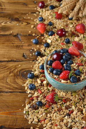 Muesli with strawberries and blueberries on a brown backgroundの写真素材