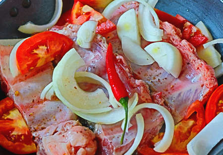 Ingredients for a festive dish, ribs with vegetables and spices, tomatoes, onions, red and green...