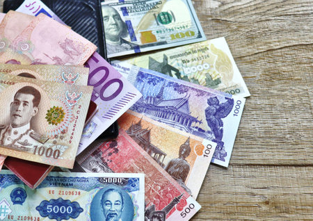 Banknotes of different countries and colors on a wooden backgroundの写真素材