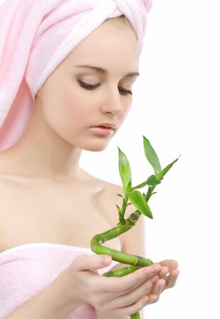 Woman in a pink towel. In the hands of a green plant bamboo.の写真素材