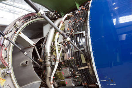 Engine of modern passenger jet plane close up. The bonnet is open. Engine maintenance and repair.