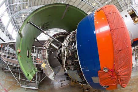 Engine of modern passenger jet plane close up. The bonnet is open. Engine maintenance and repair.