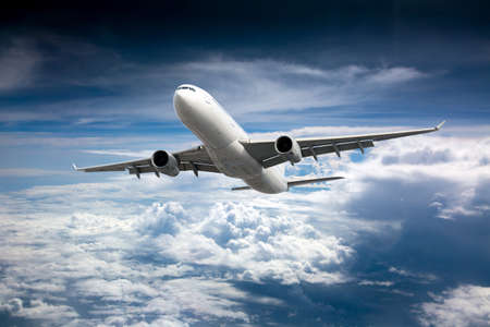 Passenger plane in flight. Aircraft flies high in the blue sky above the clouds. front view.