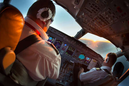 The pilots of the passenger plane at work. Closeup view in the aircraft cockpit.