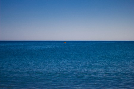 Blue calm sea against the sky. Skyline. A small red lifeline in the sea.の写真素材