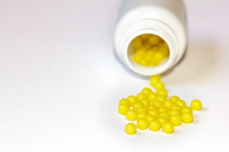 Round yellow vitamin C tablets on a white background. Ascorbic acid close-up. Vitamin C for the...