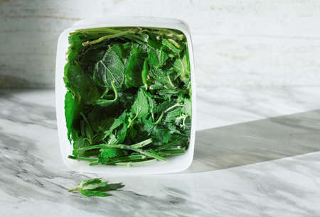 Frozen mint or Melissa. Storage of frozen food. Frozen product. Frozen green leaves of Melissa or...
