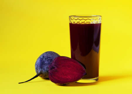 Beet juice. Fresh beetroot in a glass on a yellow background. Close up. Healthy drink. Fresh-squeezed juice beetroot.の写真素材