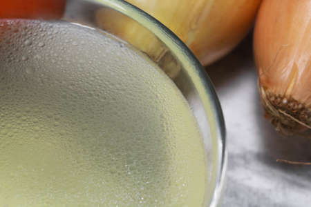 Chicken broth in a transparent plate on the background of vegetables. Close-up. Clear chicken broth. Meat broth. Healthy food. Broth for the disease.の写真素材