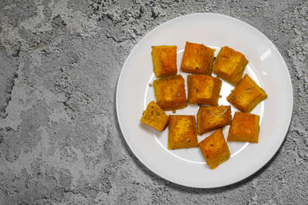 Baked pumpkin in a white plate. Pumpkin cooked in the oven. Cut pieces of pumpkin.A traditional autumn dish of baked pumpkin.の写真素材