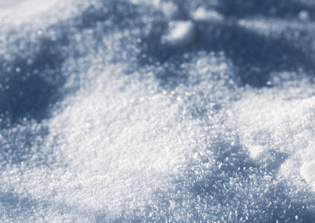 Snowy white background. The texture of the snow. Shiny snow with bokeh and blurred background close-up. White snow-covered field. Macro photo of snow.の写真素材